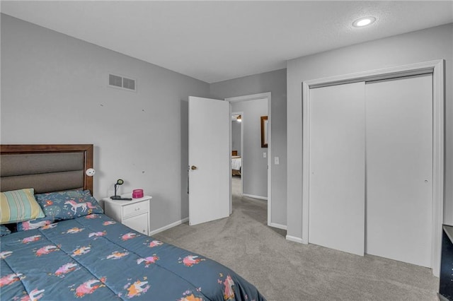 carpeted bedroom with baseboards and a closet