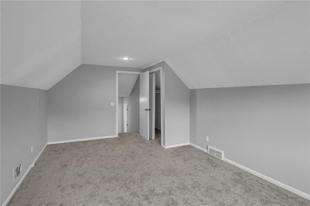 additional living space with vaulted ceiling, carpet flooring, and baseboards