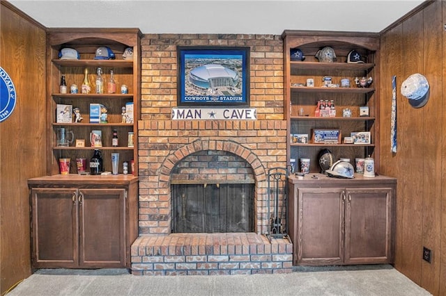 carpeted living room featuring wood walls and a fireplace