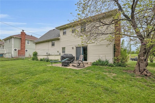 rear view of property featuring a patio area and a lawn