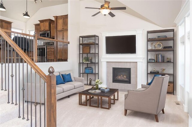 2200 NW Hedgewood Dr, Grain Valley, MO 64029 - living room featuring lofted ceiling, ceiling fan, healthy amount of natural light, stairway, and a tiled fireplace