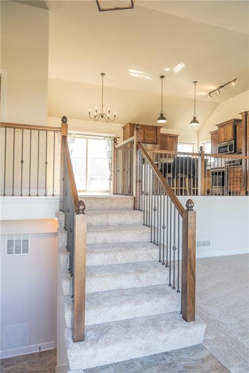 2200 NW Hedgewood Dr, Grain Valley, MO 64029 - staircase featuring carpet flooring, vaulted ceiling, a chandelier, and baseboards