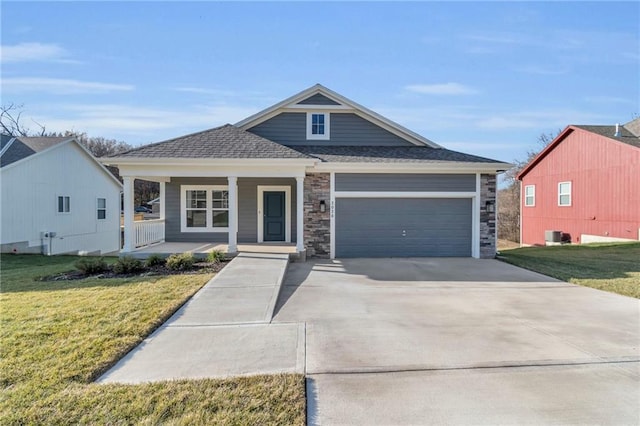 craftsman inspired home with covered porch, driveway, a front yard, and a garage