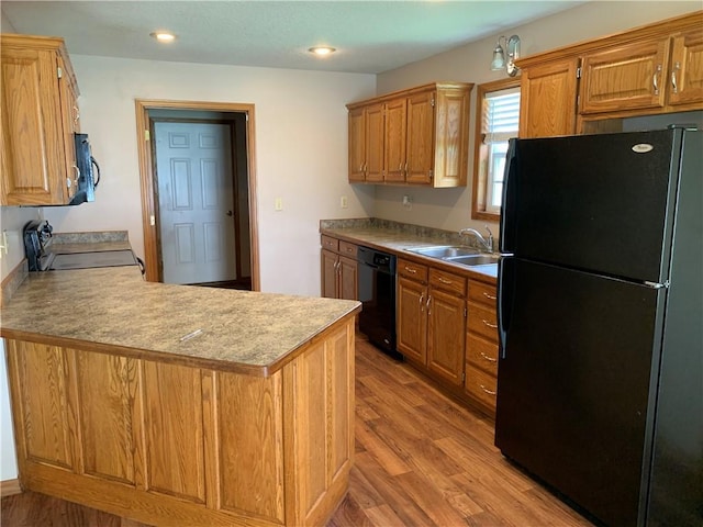 1019 S Hugh St, Frontenac, KS 66763 - kitchen featuring black appliances, light wood-type flooring, a peninsula, brown cabinets, and recessed lighting