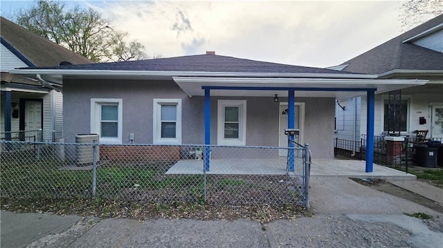 view of front of property featuring fence, covered porch, stucco siding, and a shingled roof