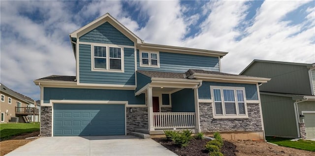 craftsman house featuring covered porch, an attached garage, driveway, and stone siding
