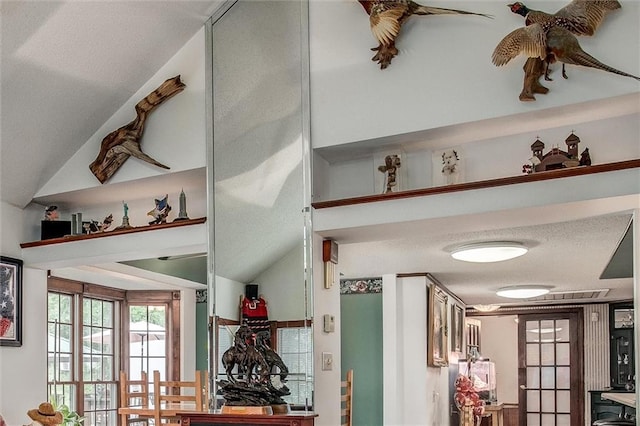 interior space with a textured ceiling and lofted ceiling