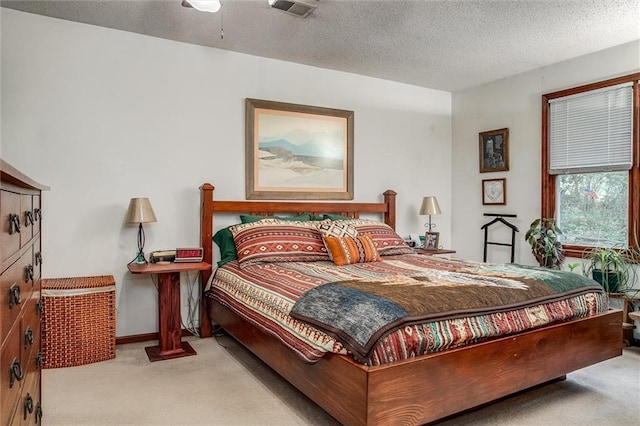 bedroom featuring carpet floors, a textured ceiling, and visible vents
