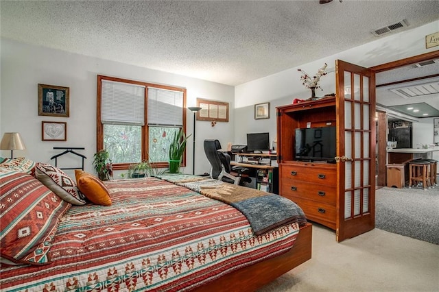 bedroom with carpet floors, a textured ceiling, and visible vents