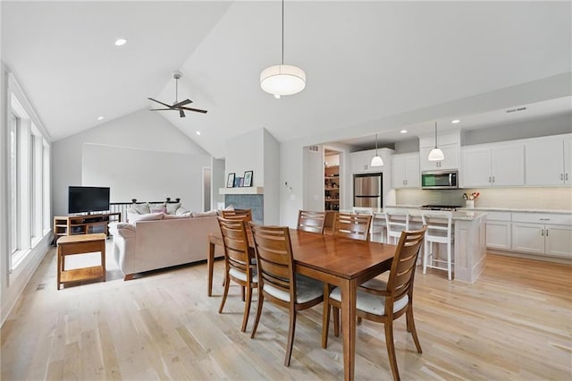dining area with recessed lighting, light wood finished floors, ceiling fan, and high vaulted ceiling