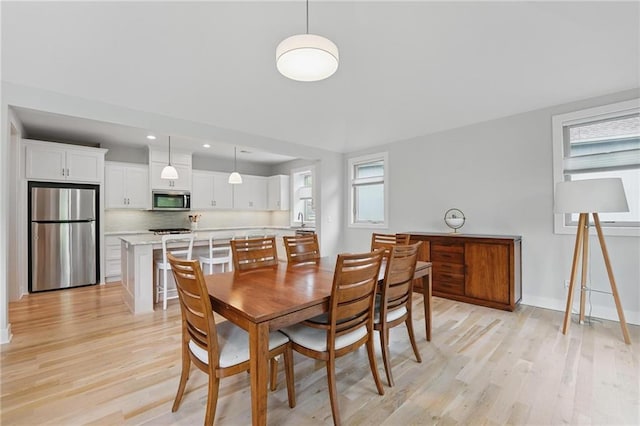 dining area with light wood-style floors, recessed lighting, and baseboards