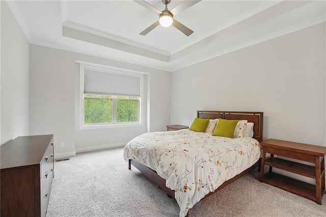 bedroom with baseboards, a ceiling fan, a raised ceiling, and light carpet