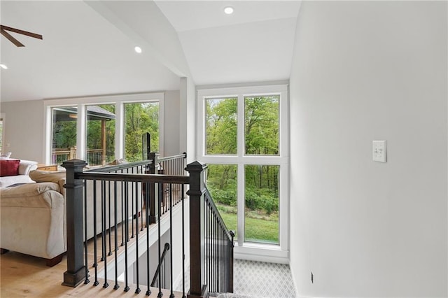 staircase with a healthy amount of sunlight, vaulted ceiling, and recessed lighting