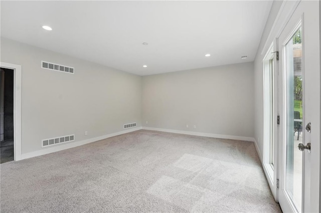 empty room with carpet, recessed lighting, and visible vents