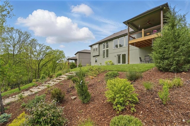 view of yard with ceiling fan and a balcony