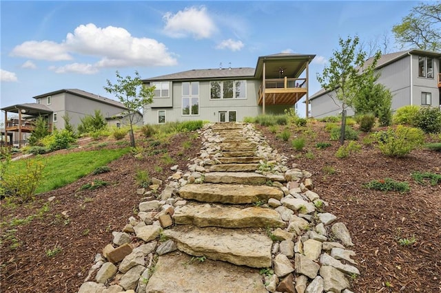 rear view of property featuring stairs and a balcony