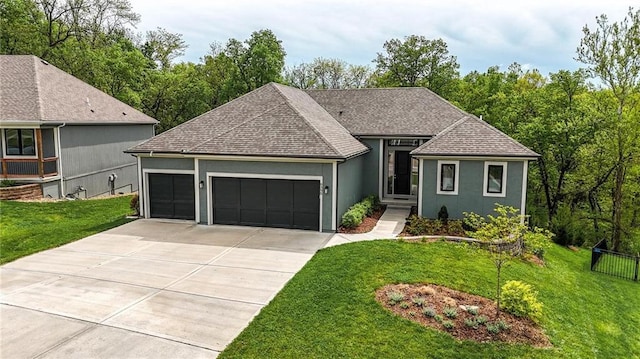 ranch-style house featuring driveway, a garage, a front lawn, a shingled roof, and stucco siding