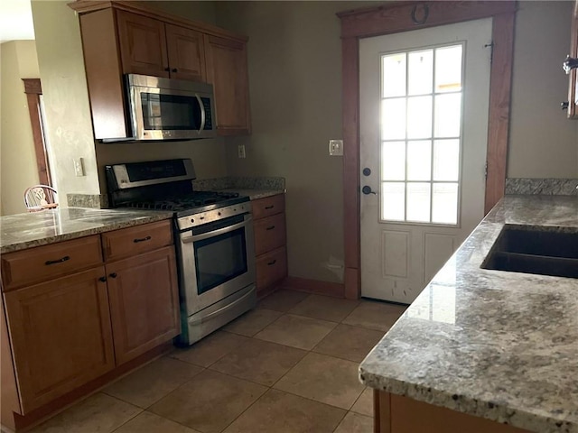 657 N 400th Rd, Overbrook, KS 66524 - kitchen featuring stainless steel appliances, light tile patterned floors, a sink, baseboards, and light stone counters