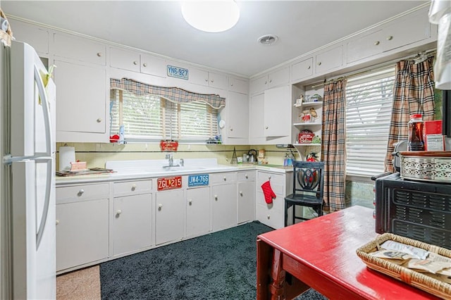 636 S Fuller Ave, Independence, MO 64052 - kitchen with freestanding refrigerator, plenty of natural light, light countertops, and crown molding