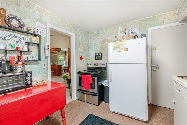 636 S Fuller Ave, Independence, MO 64052 - kitchen featuring stainless steel electric stove, freestanding refrigerator, and wallpapered walls