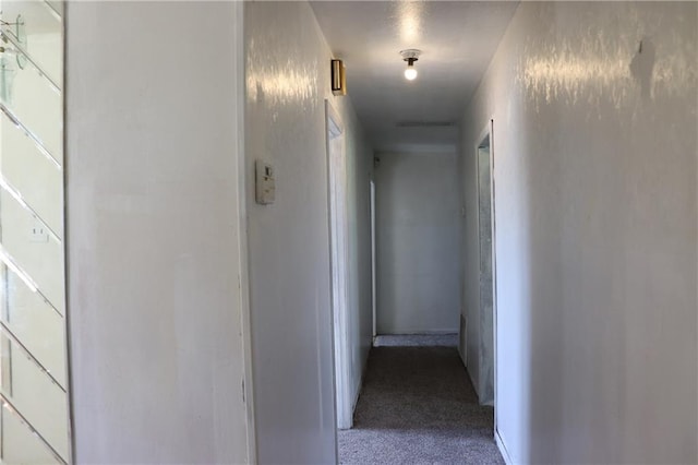 hallway with carpet floors and baseboards