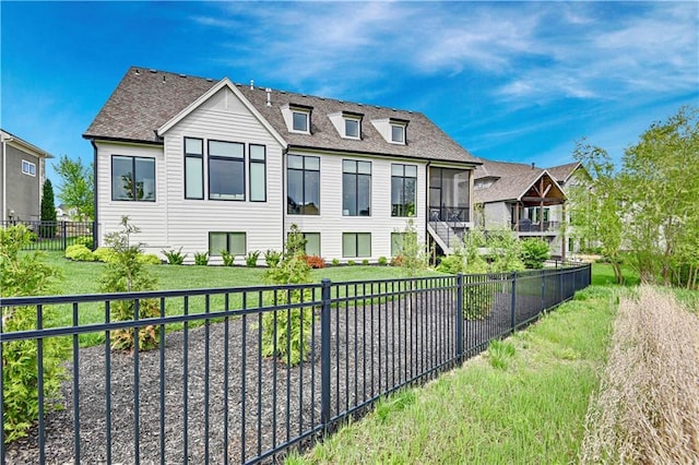 bungalow-style home featuring a fenced backyard, roof with shingles, and a front yard