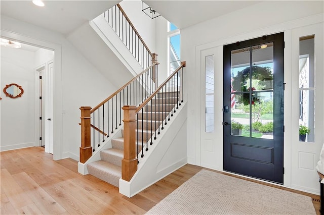 foyer entrance with stairs, recessed lighting, and light wood-type flooring