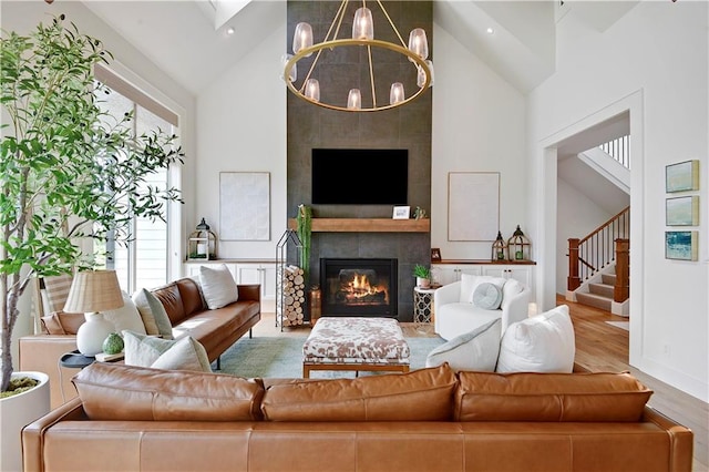 living room with an inviting chandelier, wood finished floors, a wealth of natural light, and high vaulted ceiling