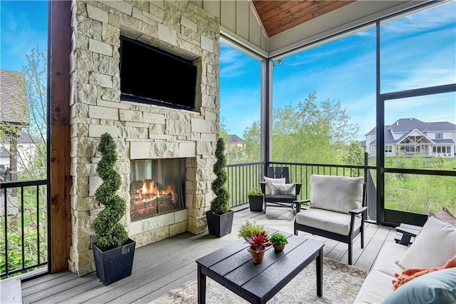 sunroom featuring an outdoor living space with a fireplace