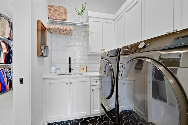 laundry room with independent washer and dryer, a sink, and cabinet space