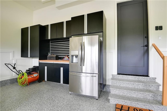 kitchen featuring dark cabinetry, stainless steel fridge, and light countertops