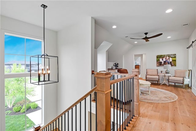 hallway with visible vents, wood finished floors, recessed lighting, a chandelier, and an upstairs landing
