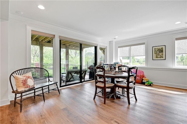 dining area with recessed lighting, ornamental molding, and wood finished floors