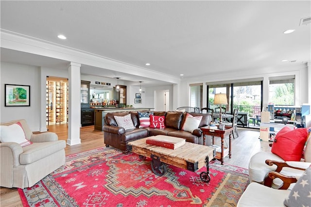 living room featuring ornate columns, visible vents, recessed lighting, and light wood-type flooring
