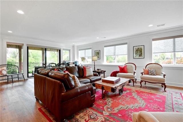 living area featuring visible vents, plenty of natural light, and wood finished floors