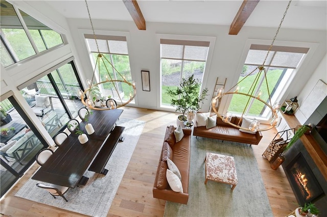 sunroom / solarium featuring an inviting chandelier, beamed ceiling, and a wealth of natural light