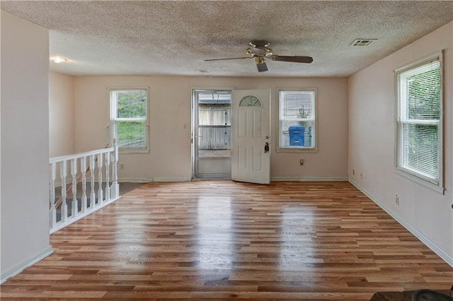 empty room featuring baseboards, a ceiling fan, wood finished floors, and visible vents