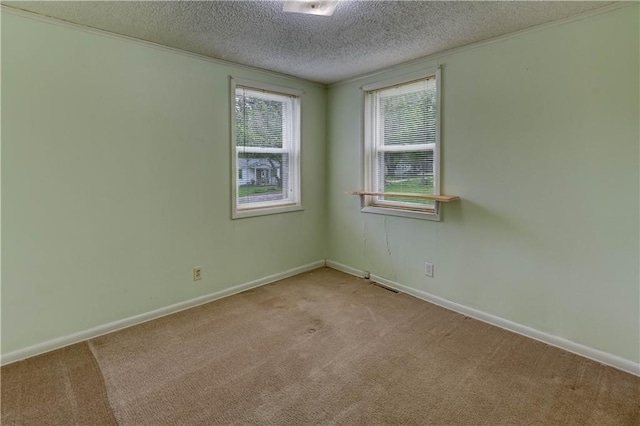 spare room featuring baseboards, visible vents, a textured ceiling, and light colored carpet