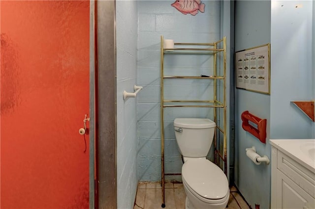 bathroom featuring vanity, tile patterned floors, and toilet