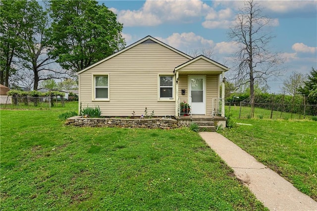 bungalow featuring a front lawn and fence