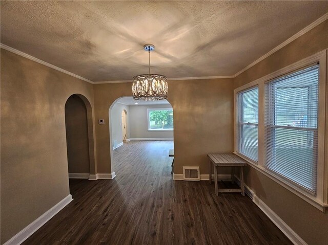 unfurnished dining area with dark wood-style flooring, arched walkways, a textured ceiling, baseboards, and visible vents