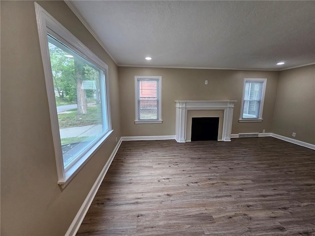 unfurnished living room with a healthy amount of sunlight, baseboards, and crown molding