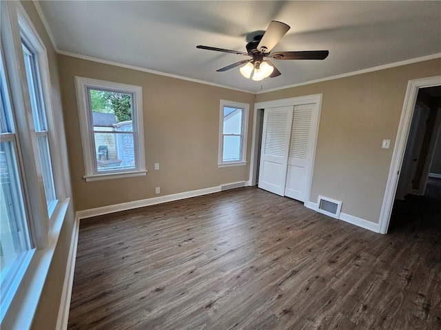 unfurnished bedroom with baseboards, visible vents, dark wood-style floors, and a closet