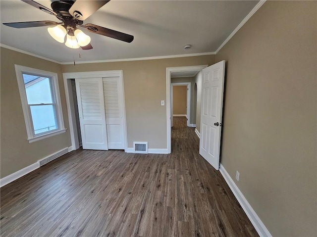 unfurnished bedroom with baseboards, visible vents, wood finished floors, and a closet
