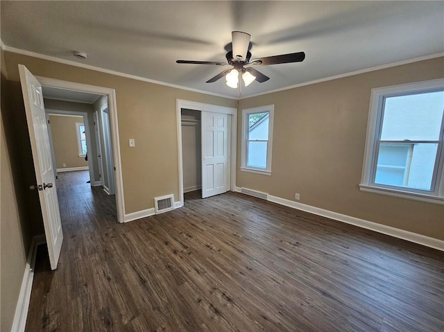 unfurnished bedroom featuring baseboards, visible vents, dark wood finished floors, and a closet