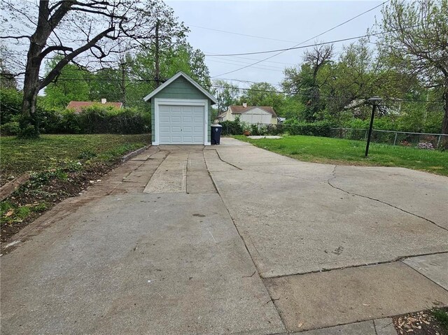 detached garage featuring fence and driveway