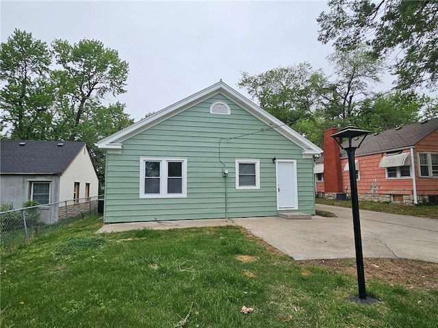 rear view of property with a lawn, fence, and a patio
