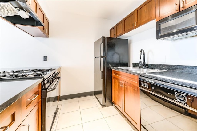 kitchen featuring brown cabinets, dark countertops, a sink, under cabinet range hood, and black appliances