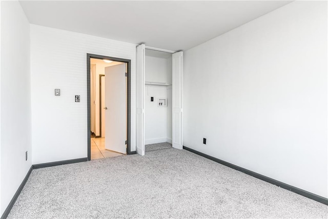 unfurnished bedroom with baseboards and light carpet