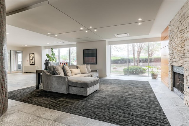 living room featuring recessed lighting, a wealth of natural light, and a fireplace